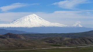 Schneebedeckte Berge unter klarem blauen Himmel mit weitläufiger Landschaft im Vordergrund, großer und kleiner Ararat