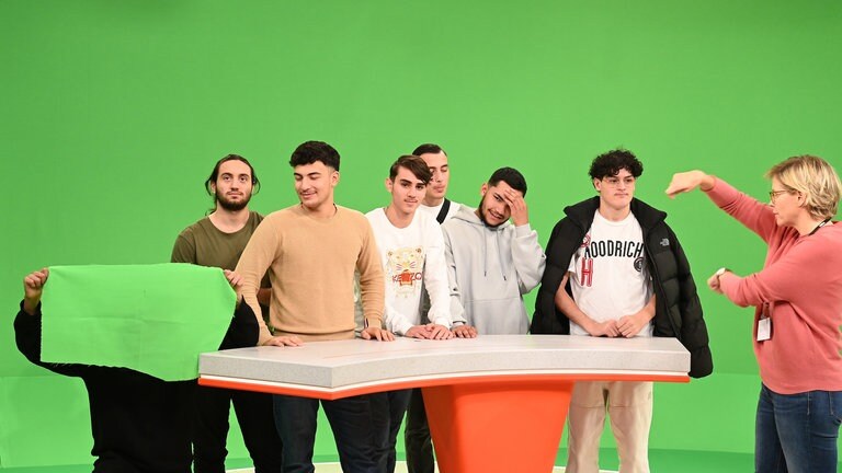 Schülergruppe in einem Fernsehstudio mit Greenscreen