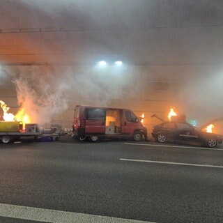 Ein Auto, ein Transporter und ein Anhänger stehen im Hechtsheimer Tunnel und brennen. 