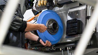 Ein Arbeiter steht an einer Industriemaschine - IHK Pfalz will gegen Fachkräftemangel vorgehen