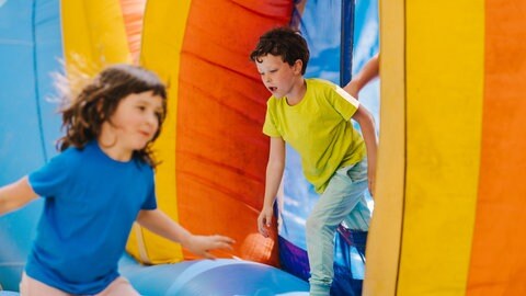 Zwei Kinder rennen durch einen Parcour.