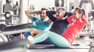 Leute machen Bauchübungen im Fitnessstudio