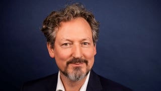 Arzt und Fernsehmoderator Eckart von Hirschhausen lächelt verschmitzt in die Kamera.
