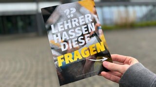Ein Flyer, der im Mai 2025 von der Identitären Bewegung an Schulen verteilt wurde, vor einem Gymnasium in Neu-Ulm. Auf dem Flyer steht: "Lehrer hassen diese Fragen".