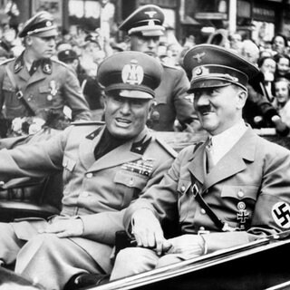 Adolf Hitler und der italienische Diktator Benito Mussolini (links) gut gelaunt im offenen Wagen am 29. September 1938 in München anlässlich der Konferenz zur tschechischen Krise. Hitler hatte Mussolini am Bahnhof abgeholt und zusammen fuhren sie im Auto weiter zum Ort der Münchner Konferenz, dem "Braunen Haus".