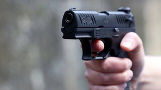 Hand mit einer Schreckschusspistole: Unbekannte haben bei Bad Sobernheim aus einem Transporter heraus Schüssen auf eine Frau abgegeben. Sie erlitt einen Schock. 