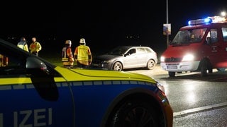 Ein Polizeiauto und ein Fahrzeug der Feuerwehr stehen am Unfallort.