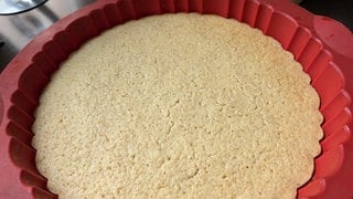Heller Tortenboden in einer runden Backform: Auf diesem Tortenboden schmecken Creme und Früchte gleichermaßen gut.