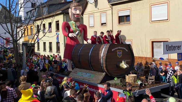 Der Umzug in HeimbachWeis zieht durch den Ort, viele Karnevalisten feiern bunt gekleidet.