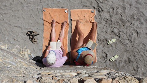 Ein lesendes Paar am Strand