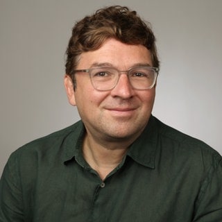 Mediziner und Wissenschaftsjournalist Dr. Christian Heinrich schaut freundlich in die Kamera.
