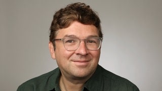 Mediziner und Wissenschaftsjournalist Dr. Christian Heinrich schaut freundlich in die Kamera.