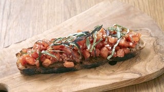 Scharweie mit Tomate auf einem Holzbrett