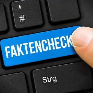Finger auf Computertaste mit Aufschrift Faktencheck