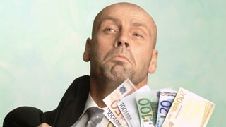 Ein Mann gibt mit einer Handvoll Geldscheine an | Kommunikation: Was tun, wenn Angeber loslegen?
