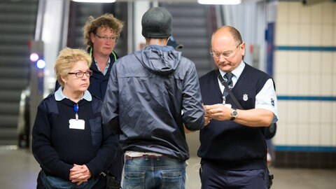 Kontrolleure überprüfen am Ausgang einer U-Bahn Station die Fahrscheine von Reisenden.