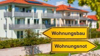 Neubauten, davor Wegweiser "Wohnungsbau": Strenge Vorschriften und Normen treiben die Baukosten in die Höhe. Pilotbauten zeigen, wie es anders geht – auch wenn dabei manche Regel gebrochen wird. Die Bundesregierung will das jetzt per Gesetz ermöglichen.