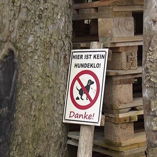 Ein Schild gegen Hundekot an einer Wiese