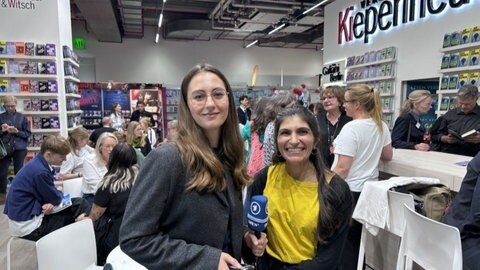Shida Bazyar und SWR Kulturredakteurin Kristine Harthauer vor dem Messestand des Verlags Kiepenheuer & Witsch