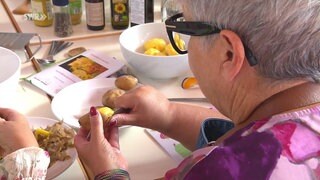 Eine Frau schält Kartoffeln.