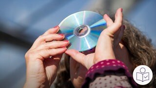 Eine Frau schaut durch eine CD in die Sonne. Rechts unten das SWR-Logo für Leichte Sprache.