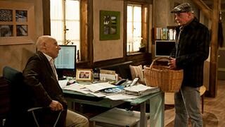 Heinz steht an Franzens Schreibtisch, Franz sitzt vor seinem Computer