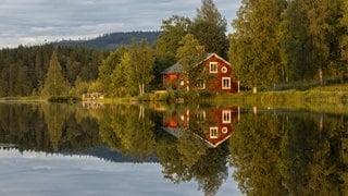 Rotes Holzhaus am See in Schweden