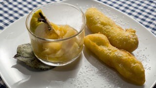 Kartoffelstumpen mit Quittenmus und Puderzzucker auf dem Teller