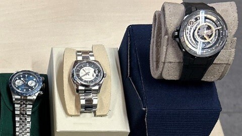 Fünf Armbanduhren liegen auf einem Tisch
