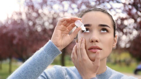 Pollenallergie: Frau nimmt Augentropfen