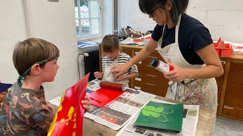 Kinder lernen japanischen Papierdruck in der Jugendkunstschule Trier. 