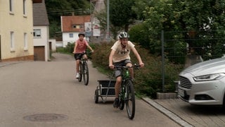 Zwei Jungs, zwei Fahrräder, ein Anhänger - Noah (vorne) und Liam bei ihrer Kronkorken Sammel-Tour durch Niederalfingen.