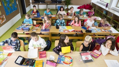Jungs und Mädchen sitzen im Mathe Unterricht in der Schule.
