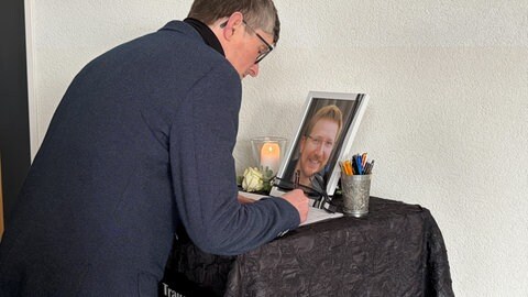 Trauernde tragen sich ins Kondolenzbuch ein