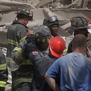Feuerwehrleute durchsuchen die Trümmer, nachdem Terroristen am Dienstag, den 11. September 2001, zwei Flugzeuge in das World Trade Center in New York steuerten und die Türme zum Einsturz brachten