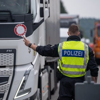 Polizisten kontrollieren Fahrzeuge auf der A64 bei Trier.