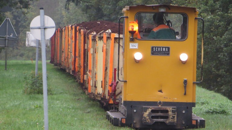 Auf ebener Strecke schafft eine Lok 40 vollbeladene Wagen zu ziehen; rund zwei Stunden ist sie auf ihrem Weg ins Moor und wieder zurück zum Werk.