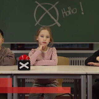 drei Kinder vor einer Schultafel
