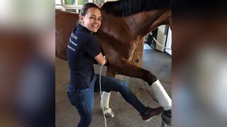 Tierärztin Sophie Kind arbeitet im Gestüt Marbach. Sie steht neben einem Pferd und streckt ein Bein aus.