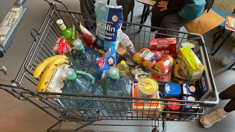 Ein Einkaufswagen voller Lebensmittel. Ein Beispiel dafür, wie viele Lebensmittel man braucht, wenn man wegen eines Katastrophenfalls oder einer Notlage mehrere Tage zuhause bleiben muss und nicht einkaufen gehen kann.