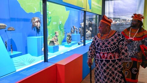 Königs Fon Sehm Mbinglo I. (links) besichtigte 2022 bei einem Besuch im Linden-Museum die ständige Ausstellung. 