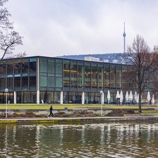 Weitwinkelaufnahme des Landtags von Baden-Württemberg in Stuttgart kurz vor der Landtagswahl 2026 mit Blick über den Eckensee. Vor dem Gebäude sind Menschen zu sehen, im Hintergrund der Stuttgarter Fernsehturm. (Symbolbild)