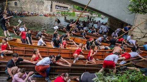 Viele Kähne versuchen beim Tübinger Stocherkahnrennen durch das enge Nadelöhr zwischen Neckarinsel und Eberhardsbrücke zu fahren. 