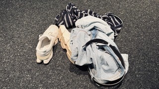 Kleidung und Schuhe liegen auf einem Haufen