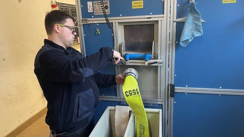 Dirk Rosenbaum steht an der Maschine, die die Feuerwehrschläuche in Nierstein reinigt