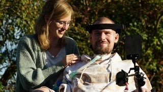 Anne steht neben ihrem Bruder Jan, der im Rollstuhl sitzt.