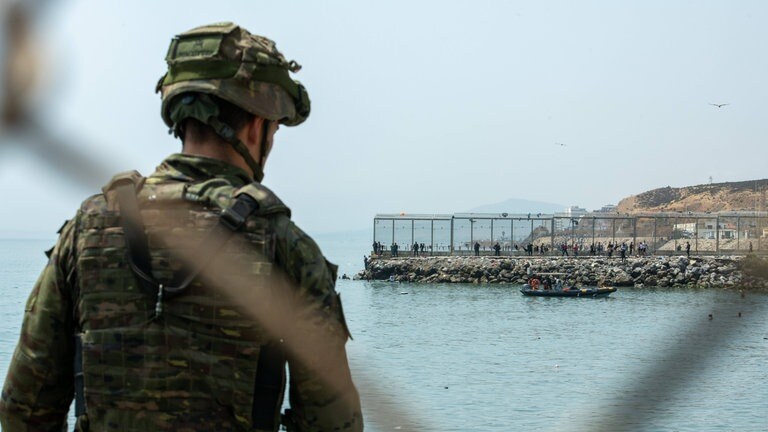 Soldaten beobachten die Lage, während Hunderte von Migranten versuchen, von Marokko aus in die spanische Stadt Ceuta in Nordafrika zu schwimmen.