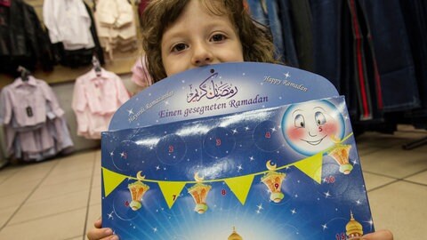 Ein Kind hält einen Ramadan-Kalender