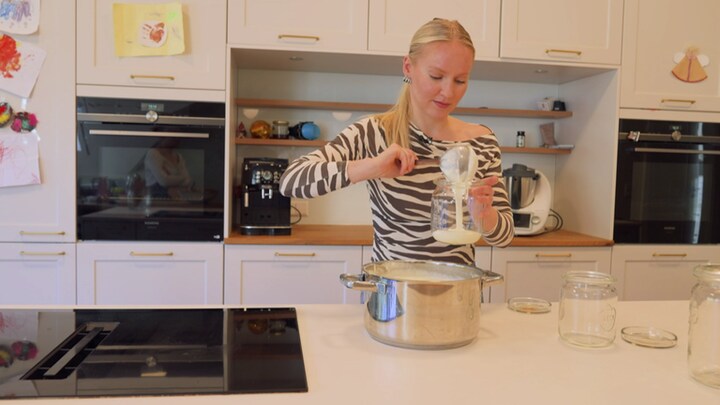 Sarah Schwenk steht in der Küche und füllt selbstgemachten Joghurt in Glasbehälter. Die ARD-Reportage "Bundesvibe" zeigt Familien, die aufgrund der Energiekrise sparen müssen. 