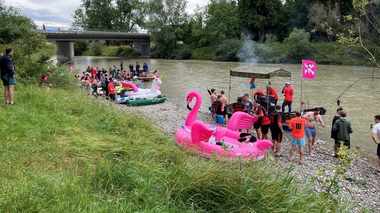Verschiedene Gummiboote in der Form von Einhörnern, Flamingos oder Piratenschiffen warten darauf, auf die Donau geschoben zu werden. 